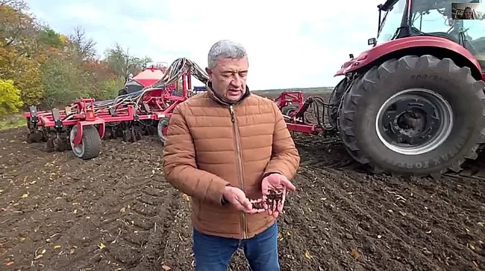 Аграрий Олег Наричук показывает, насколько хороша земля в полях после дождей