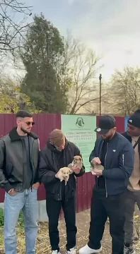 Игроки «Шерифа» Данила Форов и Джони держат на руках щенков из бендерского приюта, куда футболисты сегодня привезли корм для собак