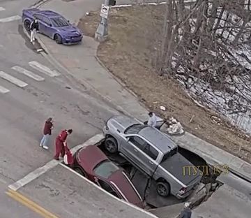 В США две машины провалились в яму, стоя на светофоре: