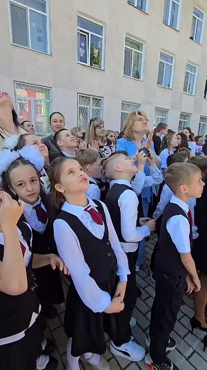 Красно-зелёные шары, запущенные выпускниками, поднимаются в безоблачное небо Приднестровья