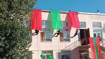 Один из самых эффектных моментов торжественной линейки в бендерской 15-й школе – спуск скалолазов с крыши здания с лентами в цветах флага ПМР