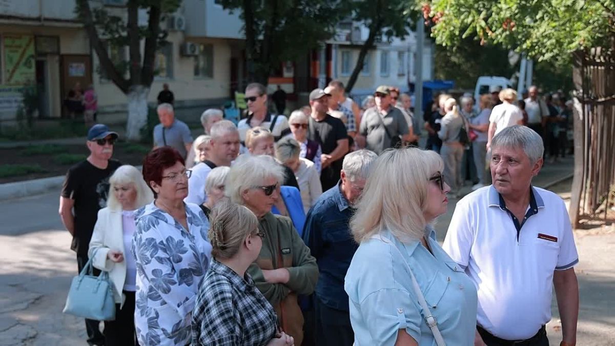 Люди стоят в очереди по 3-4 человека в ряд у 18-й школы в Тирасполе