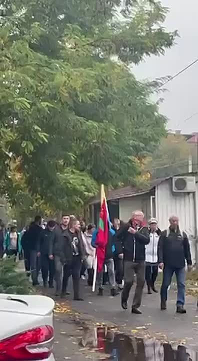 Большая группа людей с флагами Бендер идет в сторону столичного театра